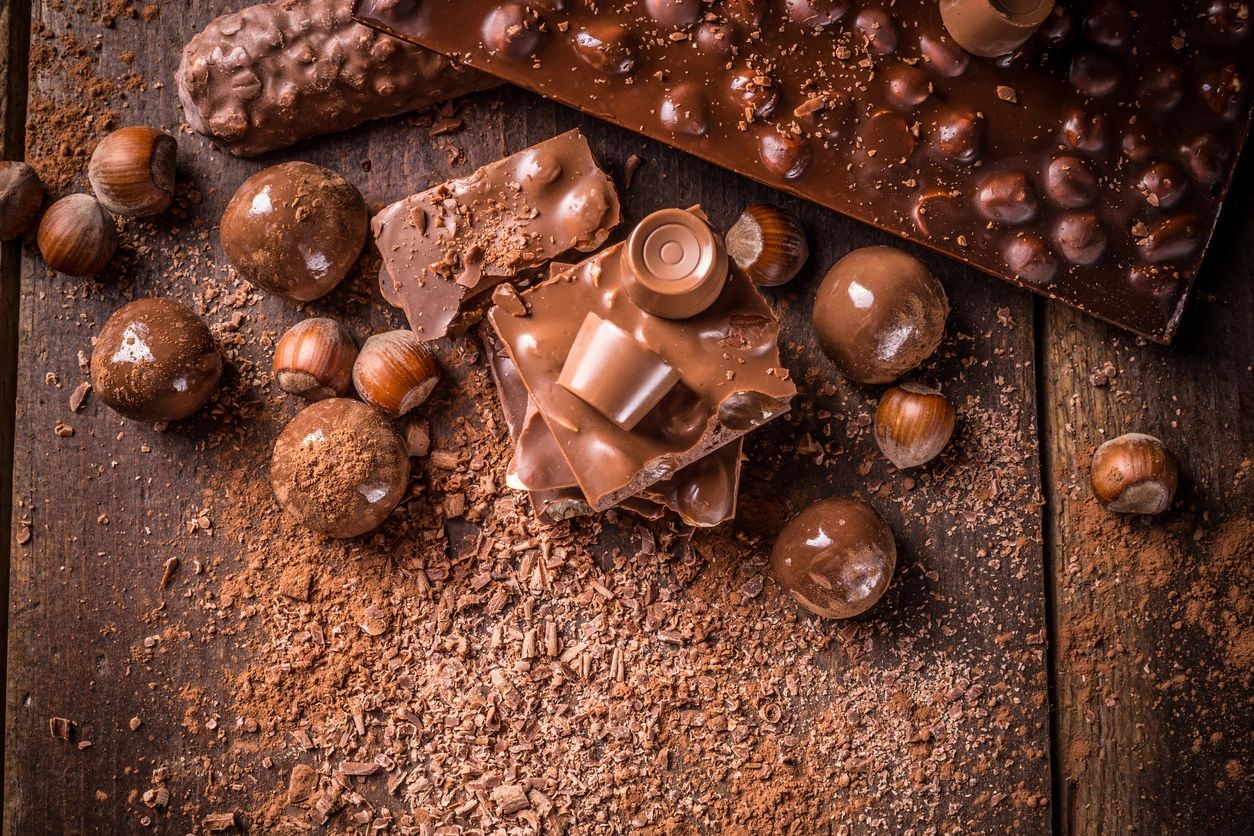Premium chocolate truffles and cocoa arranged in a flat-lay overhead composition